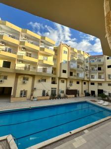 een appartementencomplex met een zwembad ervoor bij Luxury Studio in Hurghada