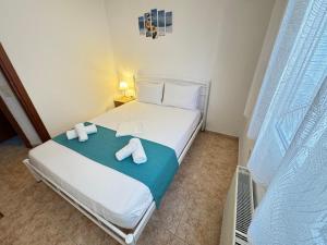 a bedroom with a white bed with towels on it at Dimado Family in Kavála