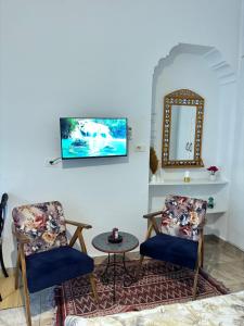 een woonkamer met twee stoelen en een tafel bij Marsa Cocon Cozy in La Marsa Beach in La Marsa