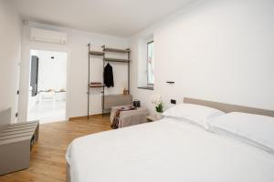 een witte slaapkamer met een groot bed en een kast bij Prince Residence in Castellammare di Stabia