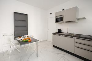 een keuken met witte kasten en een tafel met eten erop bij Prince Residence in Castellammare di Stabia