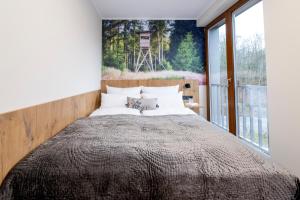 een slaapkamer met een groot bed met een groot raam bij Waldhotel Hohe Sonne in Eisenach +4 foto's