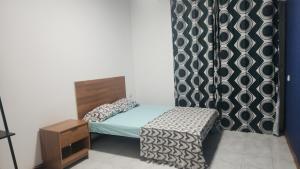 a small bedroom with a bed and a black and white curtain at Meeting Point Hostels-Praia Beachwalk-NO CASH ACCEPTED-Also in Fogo & Tarrafal in Praia