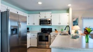 a kitchen with white cabinets and a stainless steel refrigerator at Captains House A3 in Fernandina Beach