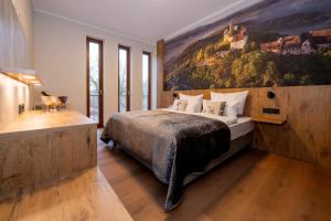 een slaapkamer met een bed met een groot schilderij aan de muur bij Waldhotel Hohe Sonne in Eisenach