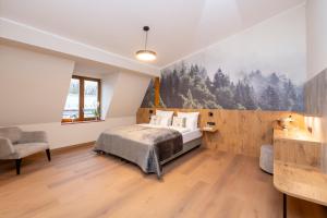 een slaapkamer met een bed en een muur met bomen bij Waldhotel Hohe Sonne in Eisenach