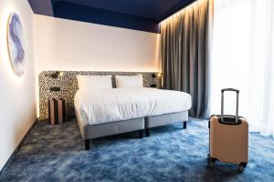 een hotelkamer met een bed en een koffer bij Mercure Bucharest Cantemir in Boekarest +29 foto's