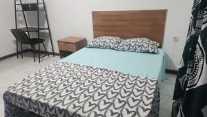 a bedroom with a bed with a black and white comforter at Meeting Point Hostels-Praia Beachwalk-NO CASH ACCEPTED-Also in Fogo & Tarrafal in Praia
