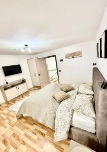 una camera da letto con un letto e un divano di Camera Family Suceava a Ipoteşti