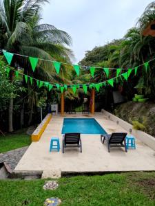 een zwembad met ligstoelen en een slinger met vlaggen bij La casa de Sonia in El Perico