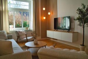 a living room with a couch and a tv at MS-Apartments I Quartier 4 in Leer
