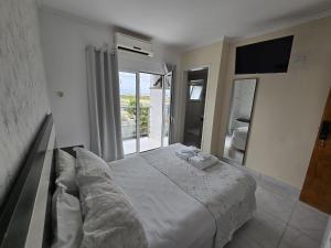 a bedroom with a large bed and a large window at Pousada Mar Alto in Ilha Comprida +40 photos