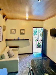 un salon avec un canapé et une table dans l'établissement Chalé Suíço - Chalés Belo Monte - Sítio Belo Monte, à Pacoti 37 autres photos