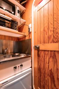 une cuisine avec une cuisinière et un micro-ondes dans l'établissement Résidence Nova - Studio 2 personnes, proche des pistes et des commerces, au cœur de la station d’Arc 1800 dans le village des Villards MAE-2572, à Arc 1800 24 autres photos