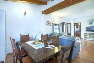 a dining room with a table and a couch at Villa Punta Magdalena in El Port