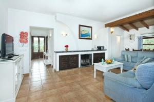 a living room with a blue couch and a fireplace at Villa Punta Magdalena in El Port