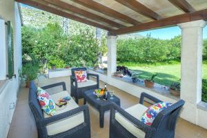 a patio with chairs and a table with drinks on it at Villa Punta Magdalena in El Port