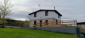 una piccola casa bianca su una collina con una recinzione di La Tadorna a Suances