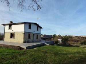 un piccolo edificio bianco su un campo erboso di La Tadorna a Suances Altre 41 foto