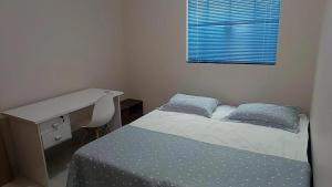 una camera con scrivania e letto e una scrivania di Casa Buritis a Primavera do Leste