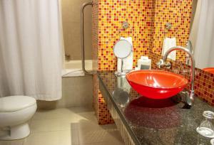 um banheiro com uma pia vermelha e um vaso sanitário em Sonesta Hotel Cali em Cali