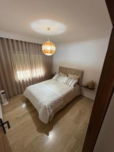 een slaapkamer met een bed en een kroonluchter bij Tanja Pearl in Tanger