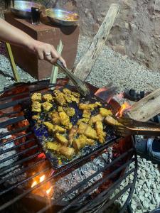 una persona está cocinando comida en una parrilla en Jungle View Homestay, en Pātan