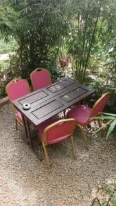 Una mesa de madera con cuatro sillas alrededor. en Jungle View Homestay, en Pātan