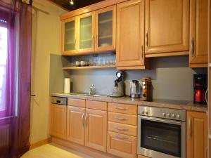 a kitchen with wooden cabinets and a sink at Wunderschöne Ferienwohnung im Burgenland in Manderscheid
