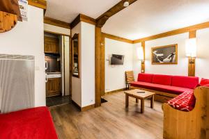 a living room with a red couch and a table at CHALET DE MONTCHAVIN - Studio pour 4 Personnes MAE-9193 in Montchavin