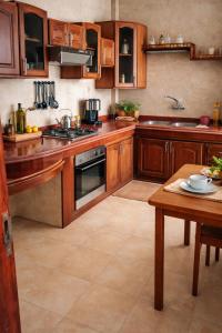 eine große Küche mit Holzschränken und einem Tisch in der Unterkunft Center Medina in Fès