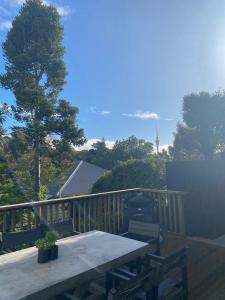 een houten terras met een tafel en stoelen erop bij Auckland City Villa in Auckland +8 foto's