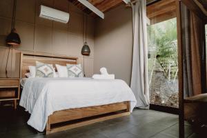 ein Schlafzimmer mit einem Bett und einem großen Fenster in der Unterkunft Armonia Santa Teresa in Playa Santa Teresa + 61 Fotos