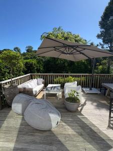 een patio met een parasol, banken en een tafel bij Auckland City Villa in Auckland