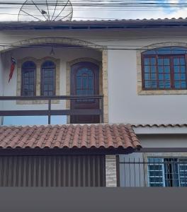 a house with three windows and a red roof at Natureza e sossego in Volta Redonda