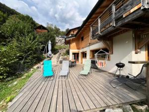een terras met stoelen en een grill op een huis bij Chalets à Saint Jean d'Aulps - BAS THEX MAE-3891 in Seytroux