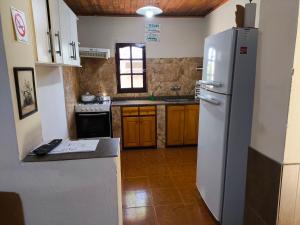 una cucina con frigorifero bianco e armadietti in legno di Lo de Toty 1 a Yapeyú Altre 29 foto