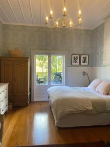 een slaapkamer met een groot bed en een kroonluchter bij Auckland City Villa in Auckland