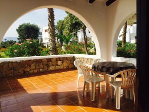 a patio with a table and chairs and a stone wall at Bahia Smir in Restinga Smir