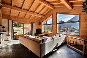 een woonkamer met een grote bank en grote ramen bij Chalets à Saint Jean d'Aulps - Coffy MAE-3601 in Saint-Jean-dʼAulps