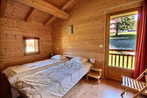 twee bedden in een blokhut met een raam bij Chalets à Saint Jean d'Aulps - Coffy MAE-3601 in Saint-Jean-dʼAulps