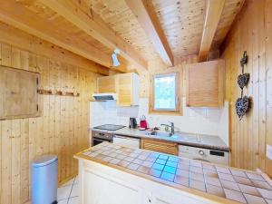 een keuken met houten wanden en een aanrecht met een wastafel bij Chalets à Châtel - Chalet Ecureuil ECR CHARMING & NATURE 5 Pers. MAE-3403 in Châtel +13 foto's