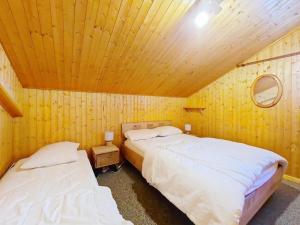 twee bedden in een kamer met een houten plafond bij Chalets à Châtel - Chalet Ecureuil ECR CHARMING & NATURE 5 Pers. MAE-3403 in Châtel
