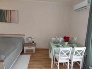a bedroom with a table with two chairs and a bed at Tímea Apartman Pécs in Pécs