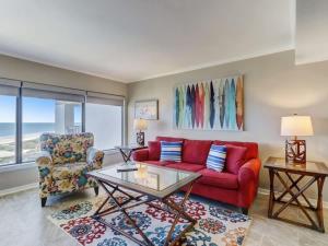 ein Wohnzimmer mit einem roten Sofa und einem Sessel in der Unterkunft Surf & Racquet Club B180 - Pool in Amelia Island