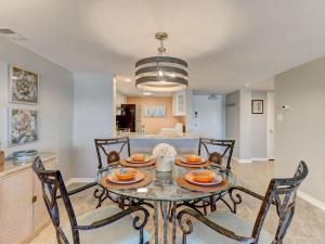 ein Esszimmer mit Glastisch und Stühlen in der Unterkunft Surf & Racquet Club B180 - Pool in Amelia Island + 17 Fotos