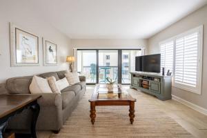 een woonkamer met een bank en een tv bij Surf & Racquet Club B160 -Pool in Amelia Island