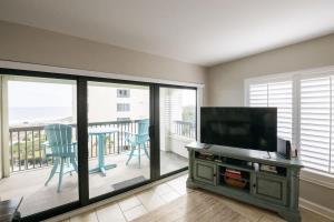 een woonkamer met een flatscreen-tv en een balkon bij Surf & Racquet Club B160 -Pool in Amelia Island