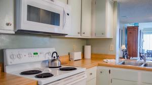 eine Küche mit einem weißen Herd und einer Mikrowelle in der Unterkunft Surf & Racquet Club C126 - Pool in Amelia Island + 20 Fotos