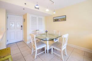 a dining room with a glass table and chairs at The Terraces #202-Condo - Pool in Fernandina Beach